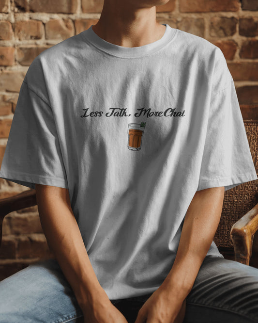 Person wearing a white t-shirt with a graphic and text against a brick wall background