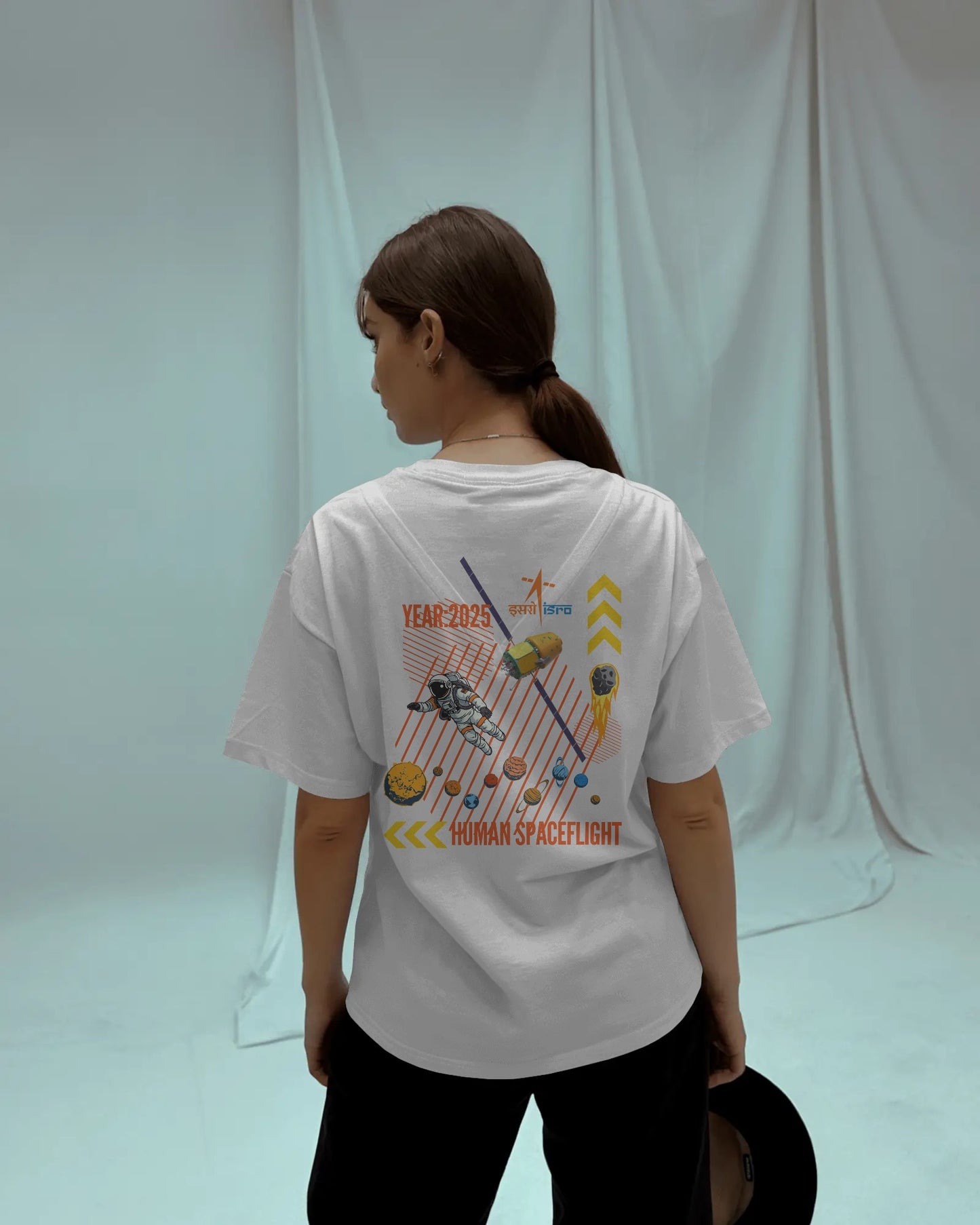Person wearing a white t-shirt with a graphic design on the back against a plain background